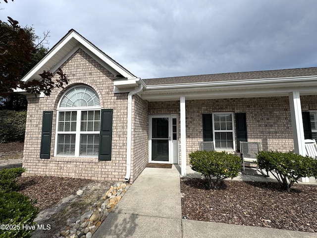4983 Kona Ct Unit 1, Southport, NC 28461 - entrance to property featuring brick siding, a porch, and roof with shingles