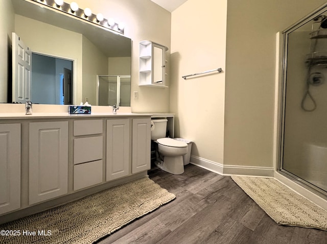 4983 Kona Ct Unit 1, Southport, NC 28461 - bathroom featuring a shower with shower door, double vanity, wood finished floors, baseboards, and toilet