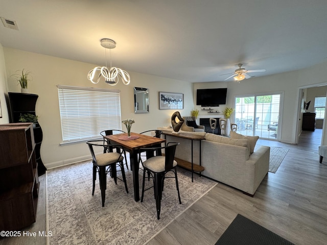 4983 Kona Ct Unit 1, Southport, NC 28461 - dining area with a ceiling fan, a chandelier, wood finished floors, and baseboards