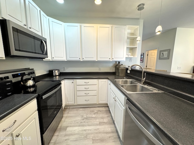 4983 Kona Ct Unit 1, Southport, NC 28461 - kitchen with appliances with stainless steel finishes, a sink, open shelves, light wood-style flooring, and white cabinetry