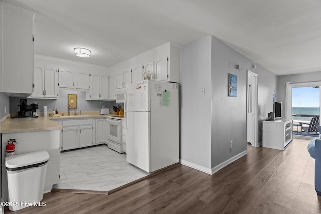 608 Carolina Beach Ave N Unit 3C, Carolina Beach, NC 28428 - kitchen with white appliances, light countertops, white cabinets, a sink, and baseboards