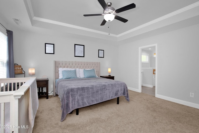 bedroom featuring a tray ceiling, light carpet, multiple windows, and ornamental molding