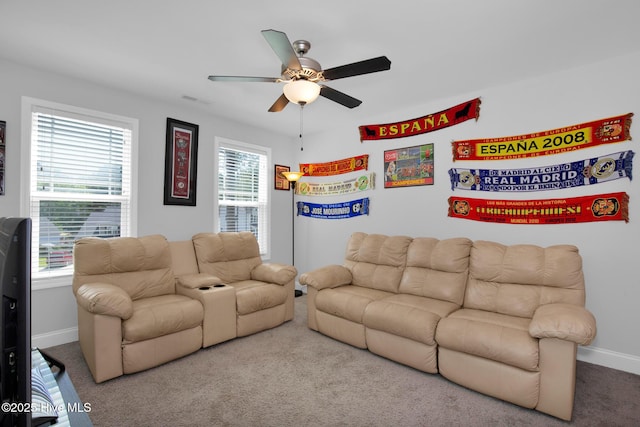 carpeted living room with ceiling fan and baseboards