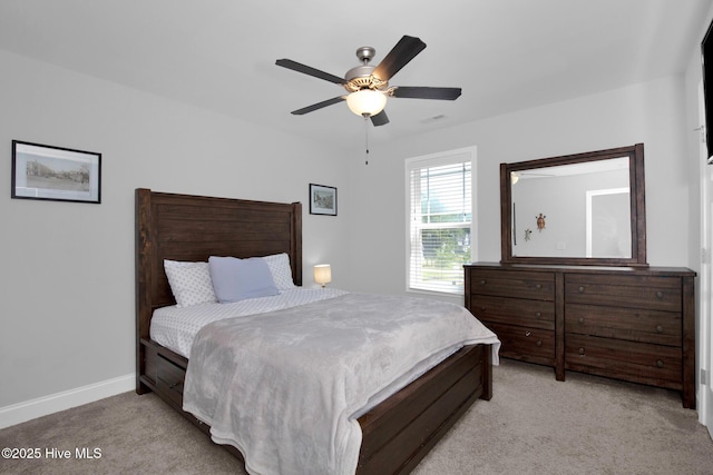 bedroom featuring light carpet, baseboards, and ceiling fan