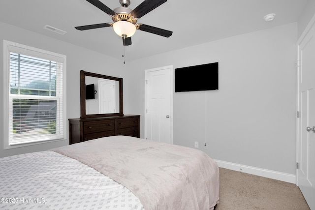 carpeted bedroom featuring baseboards and ceiling fan