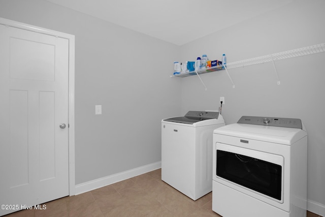 washroom with washer and clothes dryer and baseboards