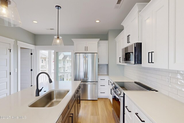 130 Sea Oaks Ct, North Topsail Beach, NC 28460 - kitchen with stainless steel appliances, a sink, light wood-style floors, light countertops, and recessed lighting