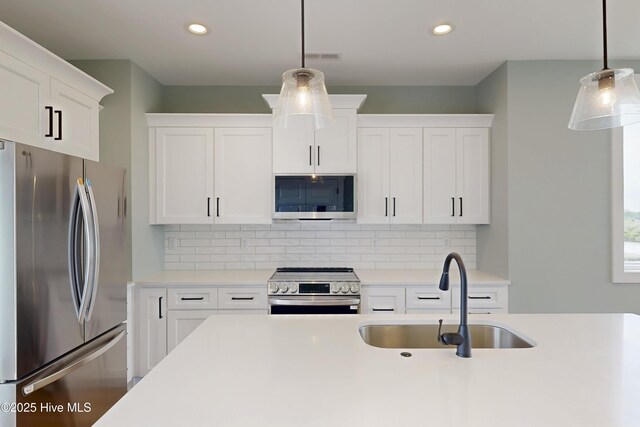 130 Sea Oaks Ct, North Topsail Beach, NC 28460 - kitchen with stainless steel appliances, a sink, light countertops, white cabinets, and recessed lighting