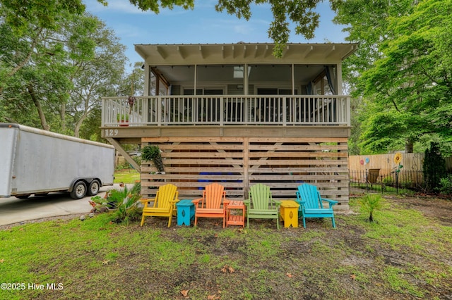 129 NE 36th St, Oak Island, NC 28465 - back of house with a sunroom, stairs, and a deck