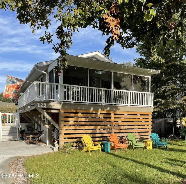 129 NE 36th St, Oak Island, NC 28465 - view of front of home with stairs, a sunroom, a deck, and a patio