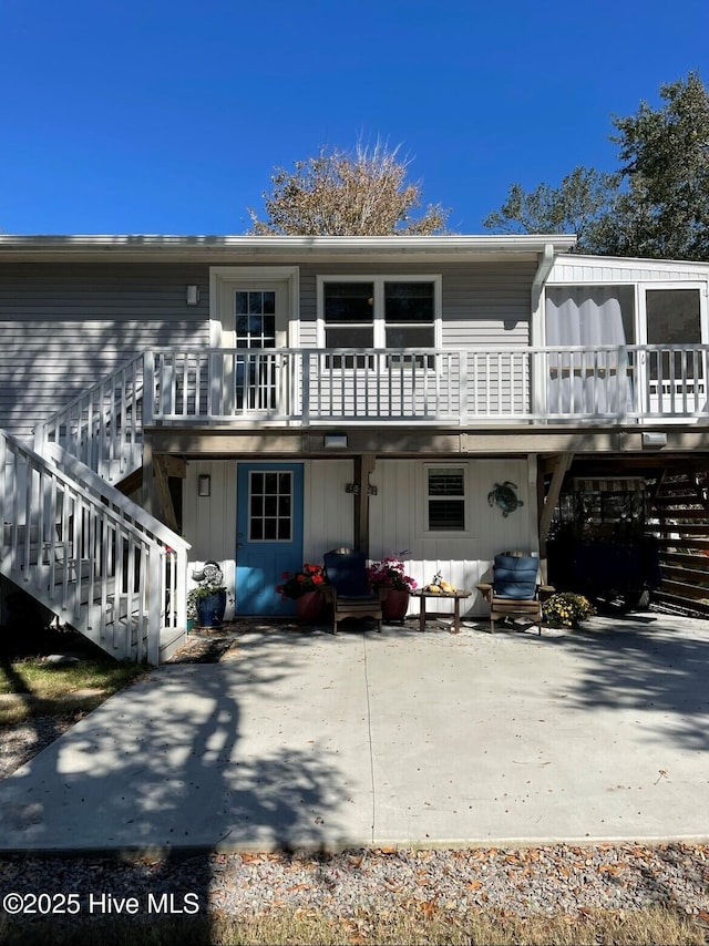 129 NE 36th St, Oak Island, NC 28465 - view of front facade featuring stairway, a patio, and a wooden deck