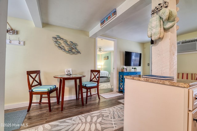 129 NE 36th St, Oak Island, NC 28465 - kitchen featuring wood finished floors, a wall mounted air conditioner, beam ceiling, ceiling fan, and light stone countertops