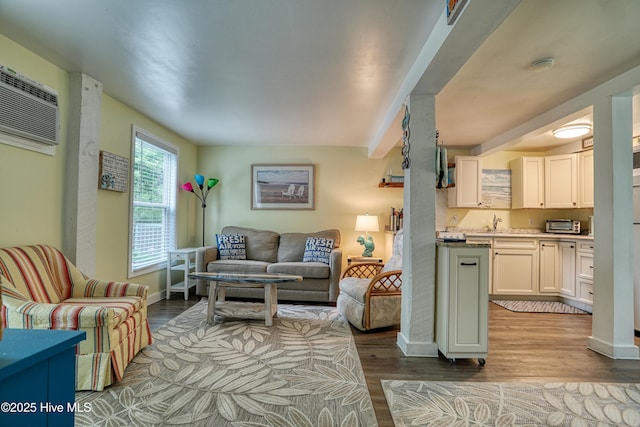 129 NE 36th St, Oak Island, NC 28465 - living room featuring baseboards, wood finished floors, and an AC wall unit