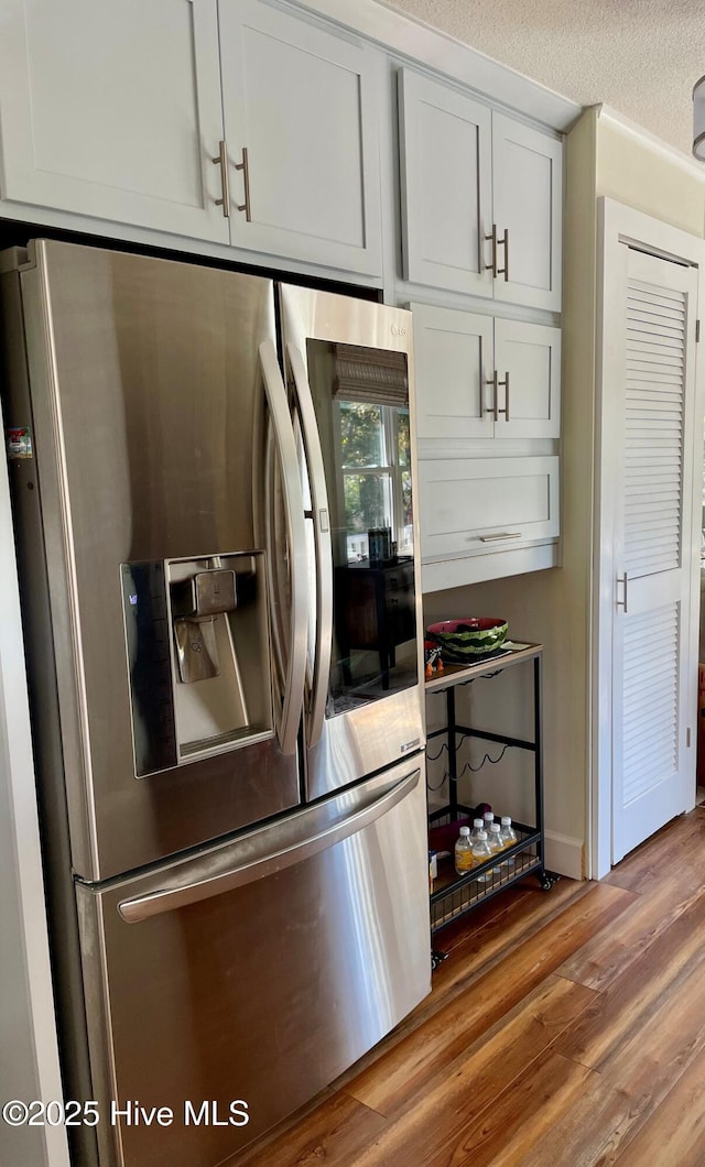 129 NE 36th St, Oak Island, NC 28465 - kitchen with stainless steel fridge and wood finished floors