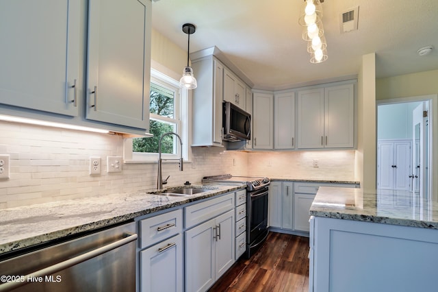 129 NE 36th St, Oak Island, NC 28465 - kitchen with stainless steel appliances, a sink, light stone countertops, and dark wood-style floors
