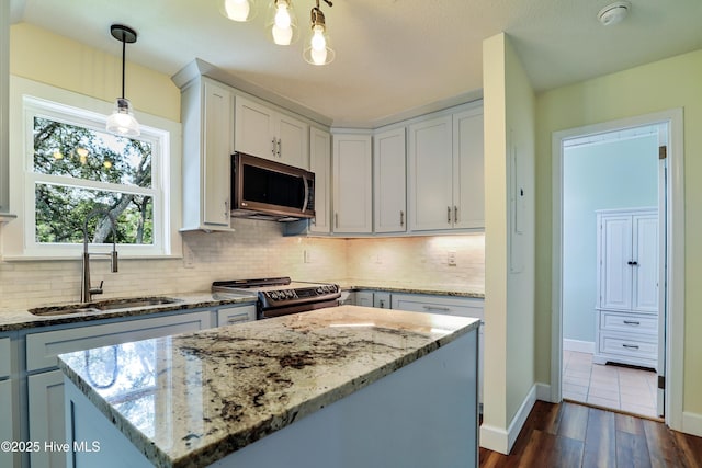 129 NE 36th St, Oak Island, NC 28465 - kitchen with stainless steel microwave, a sink, range, and decorative backsplash