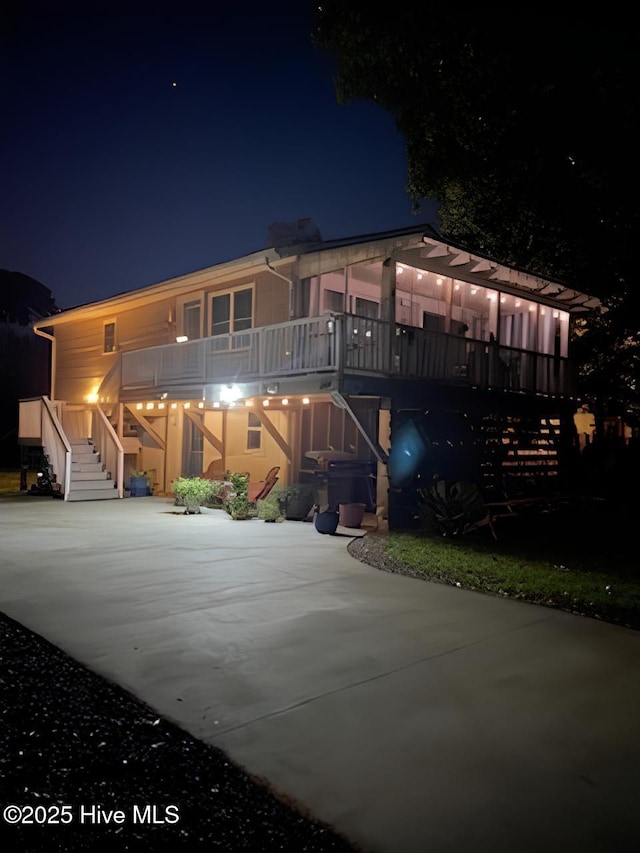 129 NE 36th St, Oak Island, NC 28465 - view of front facade featuring concrete driveway, stairs, and a carport