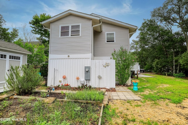 129 NE 36th St, Oak Island, NC 28465 - rear view of house with a yard and board and batten siding