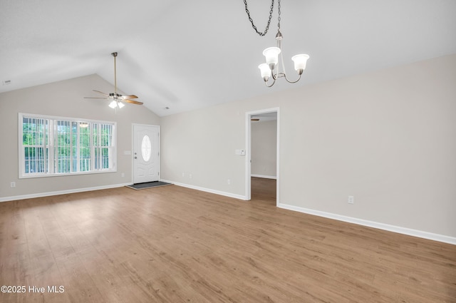 unfurnished living room featuring a chandelier, light wood-type flooring, a ceiling fan, vaulted ceiling, and baseboards