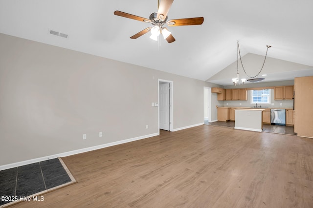 unfurnished living room featuring wood finished floors, vaulted ceiling, a sink, a ceiling fan, and baseboards