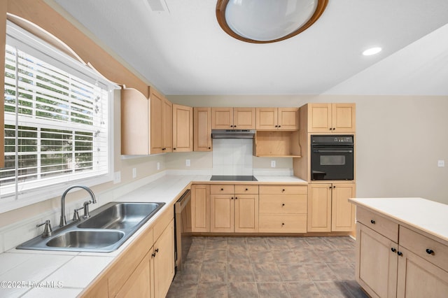 kitchen featuring light brown cabinets, black appliances, a sink, light countertops, and under cabinet range hood