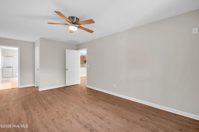 empty room featuring wood finished floors, ceiling fan, and baseboards