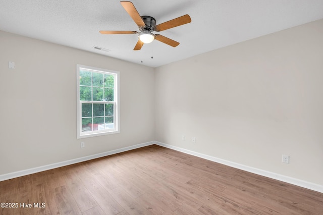 unfurnished room featuring wood finished floors, baseboards, and ceiling fan