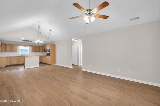 unfurnished living room with lofted ceiling, a sink, light wood-type flooring, ceiling fan, and baseboards