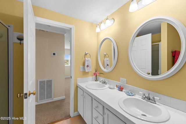 full bathroom with double vanity and a shower with shower door