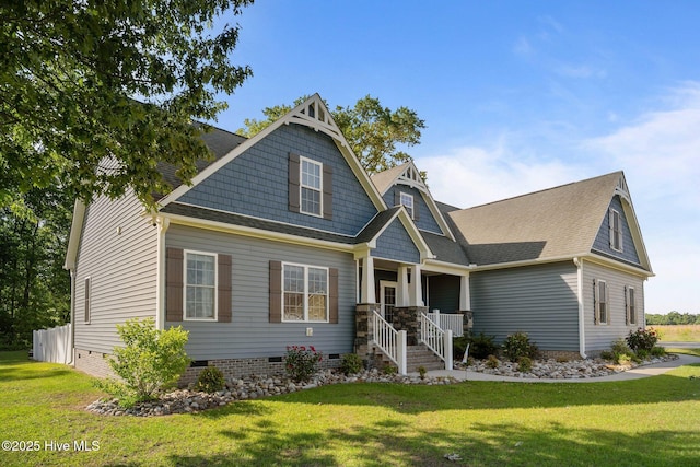 view of front of property featuring crawl space, covered porch, a front yard, and roof with shingles