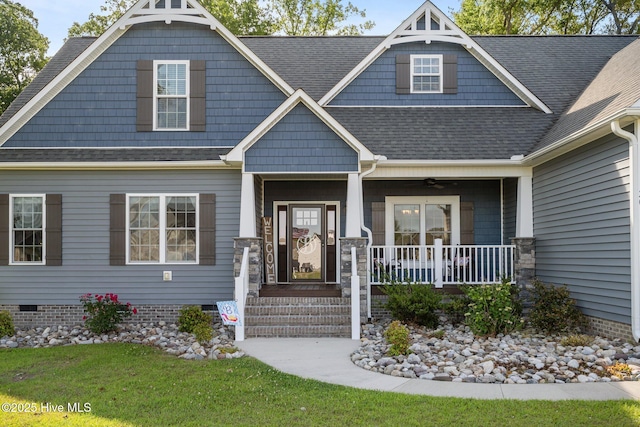 craftsman-style home with covered porch, ceiling fan, a shingled roof, a front lawn, and crawl space