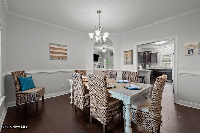 dining area featuring ornamental molding, dark wood finished floors, a chandelier, and baseboards