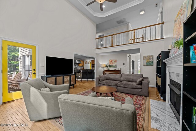 1005 Cambridge Ct, Trent Woods, NC 28562 - living room featuring crown molding, a ceiling fan, a fireplace, wood finished floors, and a high ceiling