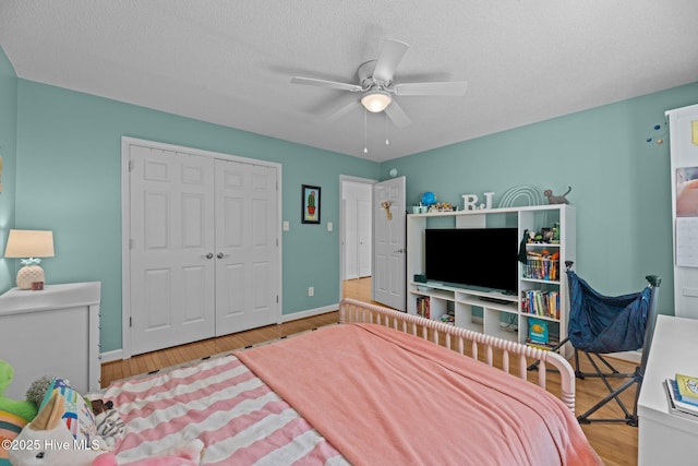 1005 Cambridge Ct, Trent Woods, NC 28562 - bedroom with wood finished floors, baseboards, a closet, a ceiling fan, and a textured ceiling