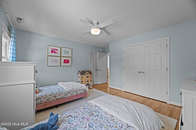 1005 Cambridge Ct, Trent Woods, NC 28562 - bedroom with light wood-type flooring, a closet, a textured ceiling, a ceiling fan, and baseboards
