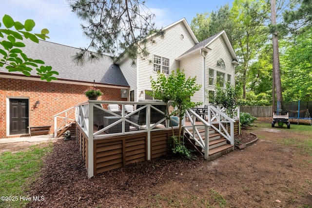 1005 Cambridge Ct, Trent Woods, NC 28562 - back of house with a trampoline, a wooden deck, roof with shingles, and fence