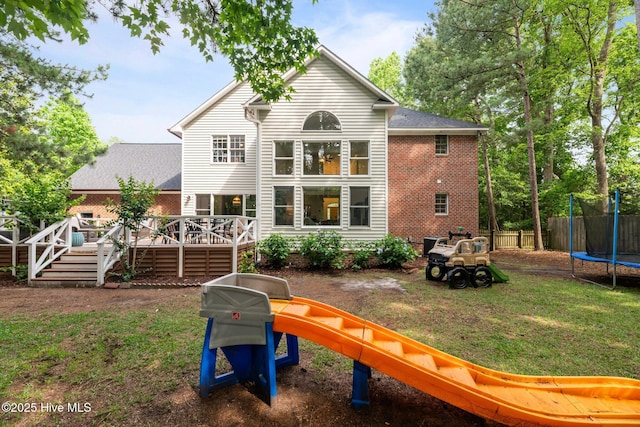 1005 Cambridge Ct, Trent Woods, NC 28562 - back of property featuring a trampoline, a wooden deck, and brick siding