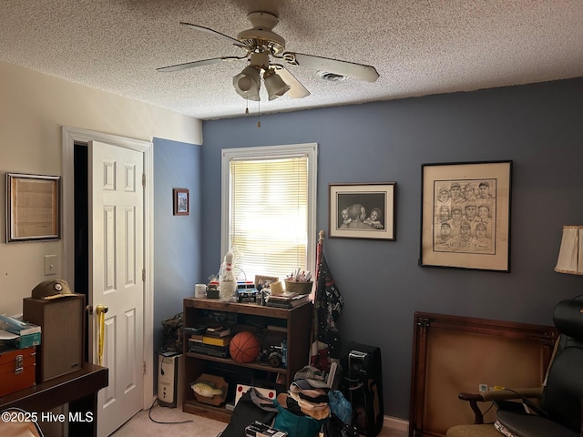 office space featuring a ceiling fan, a textured ceiling, and light colored carpet