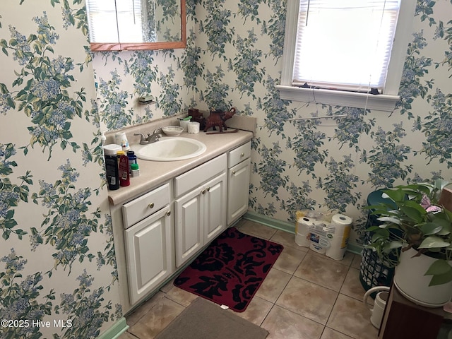 bathroom featuring tile patterned floors, vanity, baseboards, and wallpapered walls