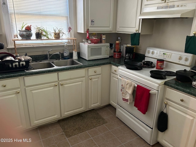 kitchen with white appliances, under cabinet range hood, a sink, and plenty of natural light