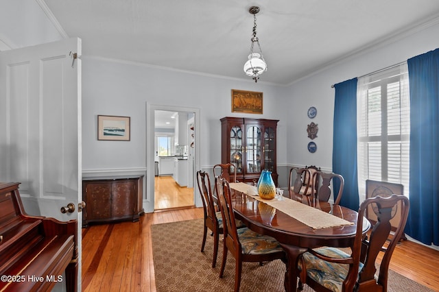 dining area with hardwood / wood-style flooring and ornamental molding