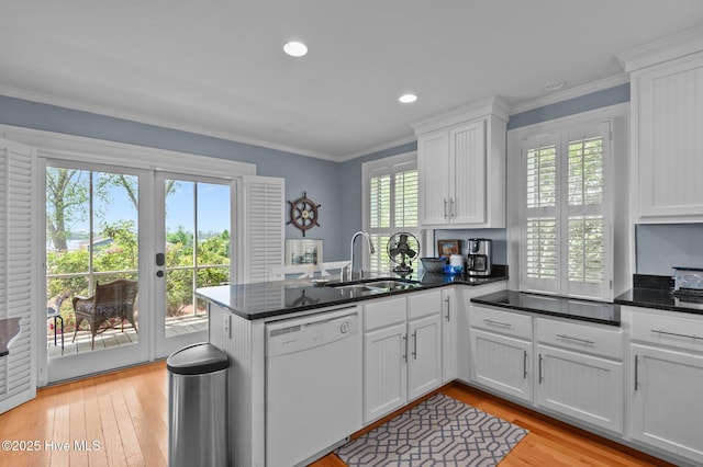 kitchen with white dishwasher, a sink, a peninsula, white cabinetry, and french doors