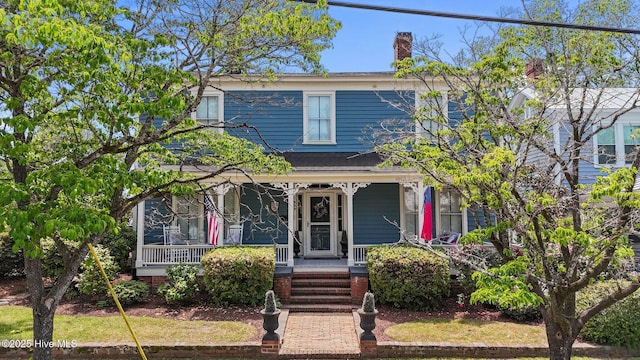 view of front of house featuring covered porch and a chimney
