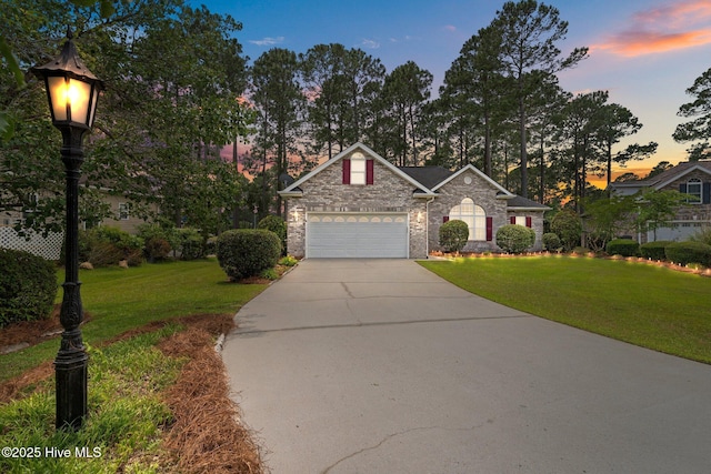 view of front of home featuring driveway, a yard, and a garage