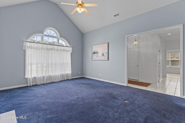spare room featuring carpet flooring, ceiling fan, high vaulted ceiling, baseboards, and tile patterned flooring