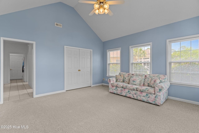 living area with carpet flooring, high vaulted ceiling, baseboards, a ceiling fan, and healthy amount of natural light