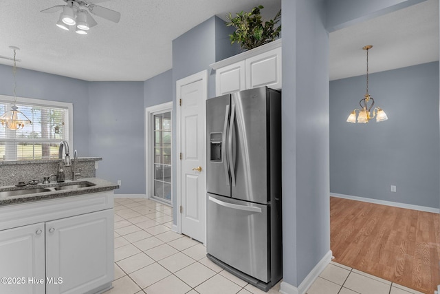 kitchen with stainless steel fridge, a sink, a chandelier, light tile patterned floors, and ceiling fan