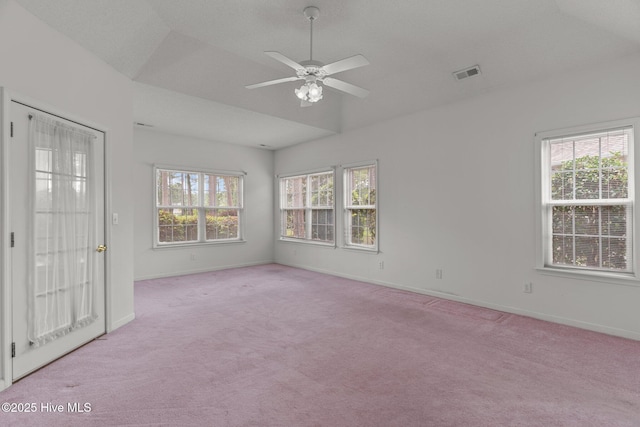 empty room featuring baseboards, light colored carpet, vaulted ceiling, and a ceiling fan