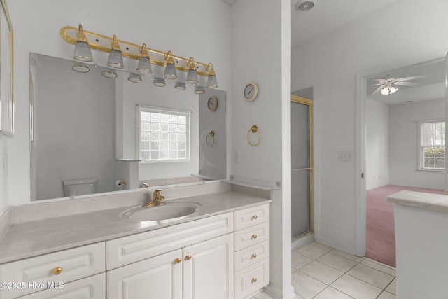 bathroom featuring tile patterned flooring, ceiling fan, a shower stall, vanity, and toilet
