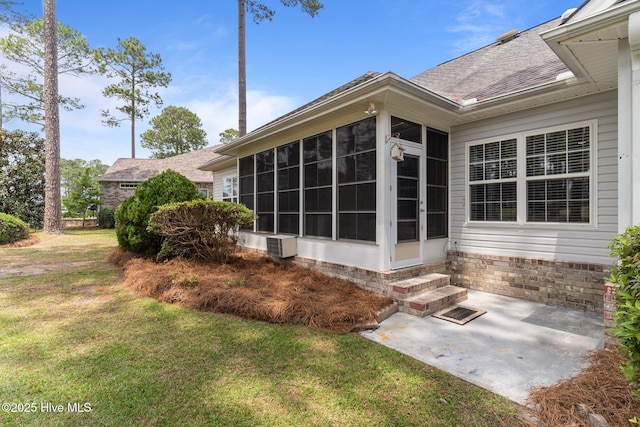view of side of home with a sunroom, a patio, entry steps, a yard, and a shingled roof